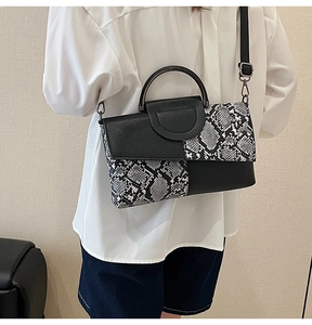 Rear view of a model wearing the snakeskin pattern crossbody bag with round metal handle