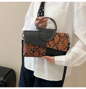 Detail of snake pattern texture and black leather splicing on fashion crossbody bag
