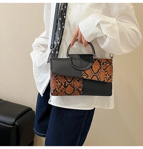 Fashionable snake pattern handbag with round metal handle and detachable crossbody strap