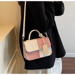 Detailed view of the pink quilted texture and metal hardware on a two-tone handbag