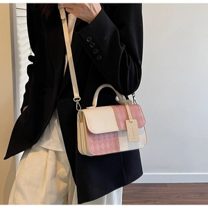 Detail shot of bicolor quilted crossbody bag with top handle and geometric texture