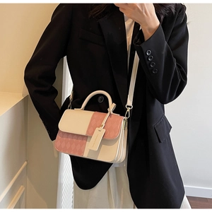 Detail of a chic cream and pink crossbody bag with diamond texture and elegant round handle
