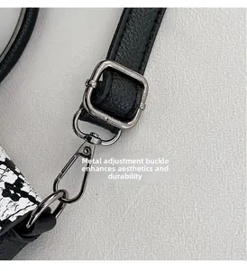 Detail of black pebbled leather strap with silver adjustable metal buckle and swivel clasp