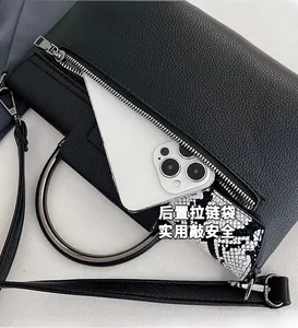 Detail of the back zipper pocket on black leather handbag for phone security and convenience