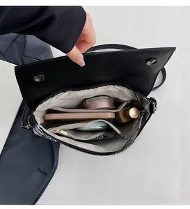 Detail view of the spacious interior compartments in this black lychee leather handbag
