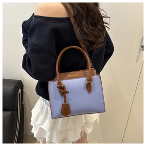 Détail de dos montrant le modèle portant un sac bandoulière lavande et marron contrasté