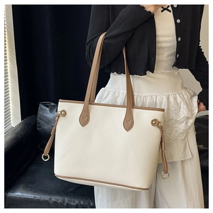Detailed macro of large off-white tote bag with lychee texture and brown contrast edges