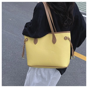 Outdoor shot of large tote bag with yellow and brown contrast leather and pebbled texture