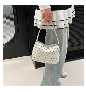 Détail du sac hobo en cuir grainé blanc avec rivets métalliques argentés polis