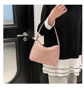 Détail de la texture cuir rose et des rivets argentés sur ce sac à main style punk