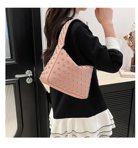 Detail of pink rivet shoulder bag with silver studs and high-quality leather texture
