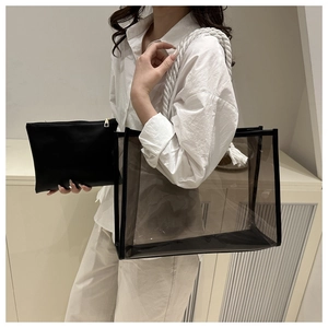 Detail of transparent PVC tote bag with white cotton rope handles and tassel decoration