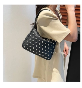 Dettaglio borsa punk in pelle nera con borchie argentate e chiusura lampo in metallo