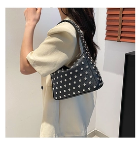 Détail des rivets argentés sur le sac porté épaule Hobo en cuir noir à grain fin