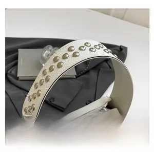 Détail de la poignée du sac blanc en cuir avec des rivets métalliques argentés