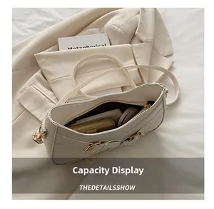 Top view of white faux crocodile underarm bag showing spacious interior and golden clasp