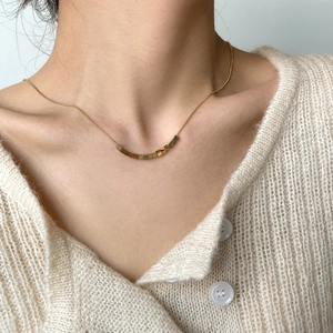 Detail of minimalist gold cube beads on a sleek snake chain necklace for women