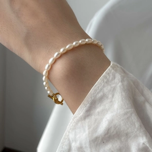 Elegant freshwater pearl bracelet with a gold-tone OT toggle clasp worn on wrist