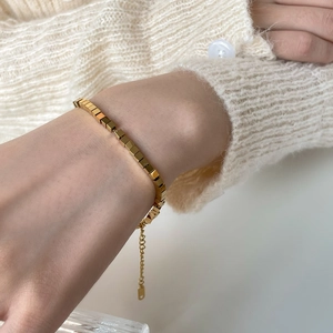 Minimalist geometric gold bracelet featuring polished cube links with adjustable chain