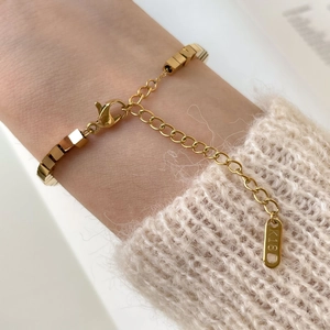 Close-up of 18K gold cube link bracelet on wrist with lobster clasp and K18 hallmark