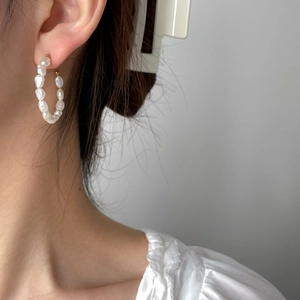 Close-up of handmade baroque pearl hoop earrings featuring elegant gold-plated metal