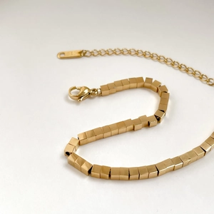 Macro shot of 18K gold cube beads with lobster clasp and adjustable extension chain