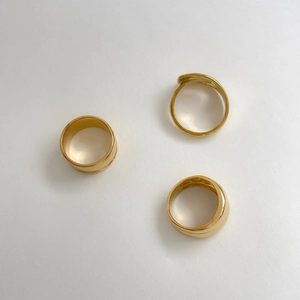 Detailed view of three minimalist irregular gold plated rings with curved hollow design