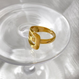 Macro shot of polished gold irregular ring featuring unique cutout buckle detail