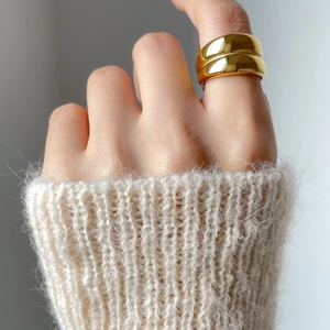 Detailed view of chunky double-layer gold irregular ring worn on index finger