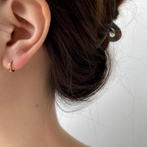 Orecchini a cerchio in oro con micro zirconi cubici indossati all'orecchio