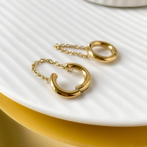 Close-up of gold plated stainless steel hoop earrings with delicate tassel chains