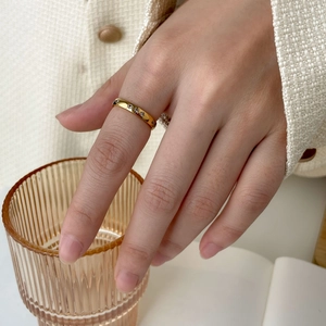 Détail d'une bague minimaliste en or 18 carats avec zircons arc-en-ciel sur un doigt