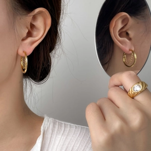 Detail of 18K gold plated circle tassel earrings and vintage wide ring with crystal