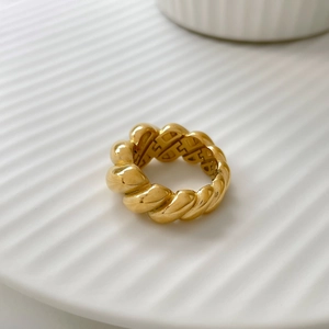 Detailed close-up of French vintage gold twisted rope ring on a ceramic plate