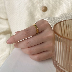 Gros plan d'une bague en or 18K avec des zircons colorés sur la main d'un modèle