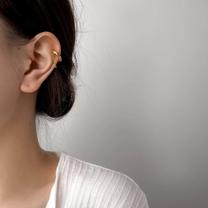 Detail of 18K gold plated tassel chain ear cuff showing polished metallic texture