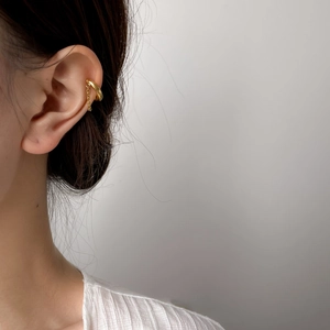 Minimalist 18K gold plated tassel chain ear cuff earring worn by a model on a grey background