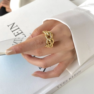 Macro detail of gold chunky twisted rope chain ring with polished mirror finish on hand