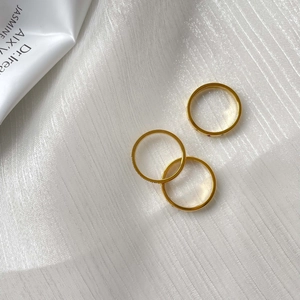 Trois bagues minimalistes en or 18K avec zircons arc-en-ciel sur tissu en soie