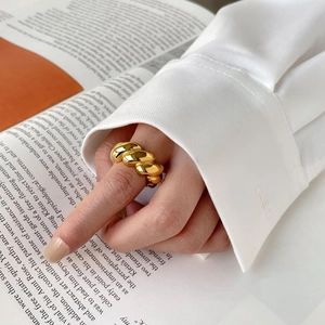 Detailed close-up of a gold twist ring showing the high-polished texture and design