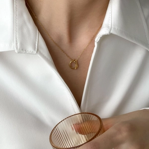 Elegant vintage irregular gold knotted necklace worn by a model on a white shirt
