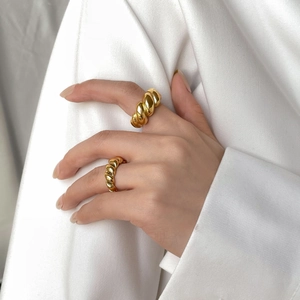French style gold plated twisted rope ring set shown on hand with elegant white fabric
