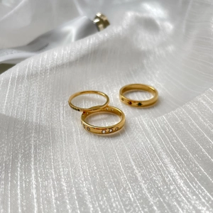 Ensemble de trois bagues empilables plaquées or 18 carats avec zircons colorés sur soie