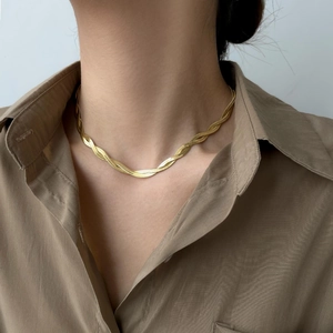 Detailed view of a gold-toned double-strand twisted snake chain necklace on a neck