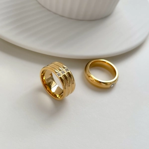 Bagues minimalistes dorées avec pierres de zircon sur des accessoires en céramique