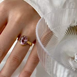 Vue détaillée d'un zircon violet ovale sur un anneau en or porté au doigt