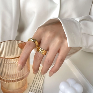 Bagues dorées chic avec zircon, design minimaliste et multicouche sur la main