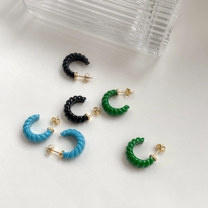Détail de boucles d'oreilles rétro C à spirale avec texture en émail coloré