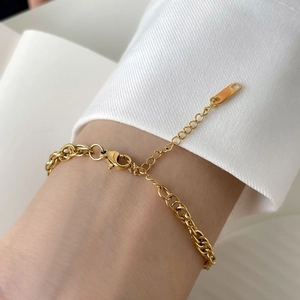 Detail of gold flat snake chain bracelet with adjustable lobster clasp on a female wrist