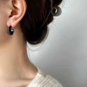 Boucles d'oreilles créoles spirales en émail noir style vintage porté par un mannequin